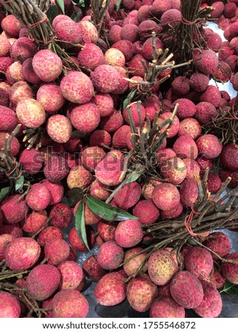 Lychee, lychee in a bunch, visible stalks and leaves in a large box, used as a background to place text or pictures