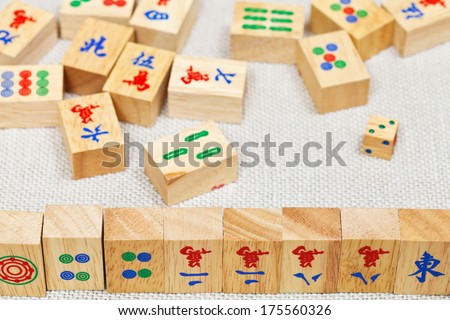 wooden tiles in mahjong game during playing on textile table close up