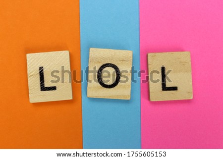 LOL - Laugh Out Loud of wooden letters on a colored striped background