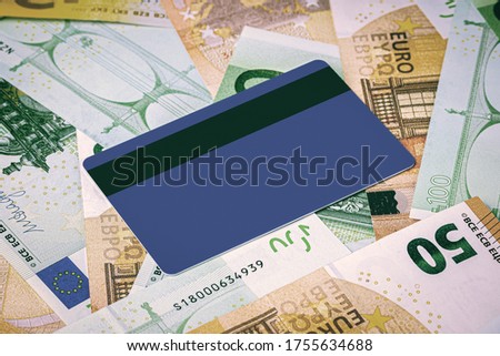 Euro bills and blue debit card with copy space for a text. The concept of electronic money and commerce. The concept of buying things on credit. Background or mock up for design.