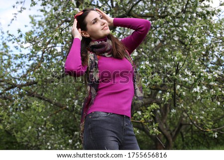 beautiful young woman with brown hair caret in a good mood positive emotions joy of a spring day in flowering trees