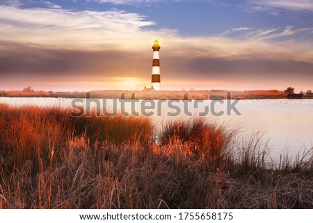 The lighthouse with marshlands soft blurry background. 