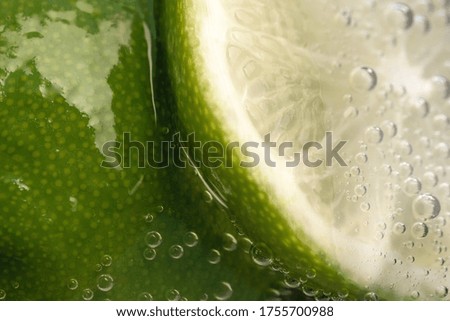 Slices of lime in a glass of soda water close-up macro photography product background