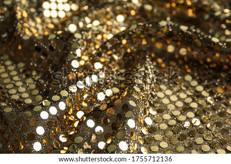 Texture of beautiful golden fabric with paillettes as background, closeup