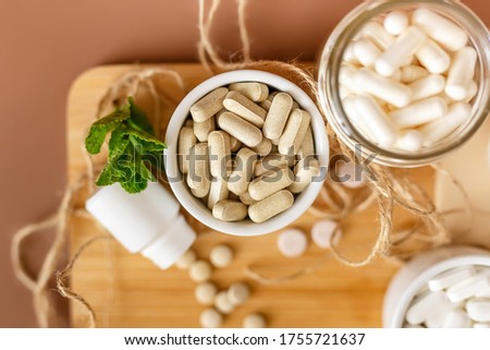 Organic natural dietary supplements, vitamins and minerals on brown background in rustic composition. Vitamins and medications for health support. Organic health care products. Royalty-Free Stock Photo #1755721637