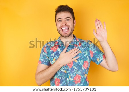 I swear, promise you not regret. Portrait of happy, sincere young man raising one arm and hold hand on heart as give oath, pledge, telling truth, want you to believe, standing over yellow background. Royalty-Free Stock Photo #1755739181