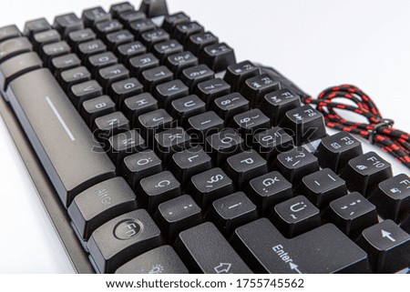 Computer keyboard. Black keyboard with a cord on a white background.