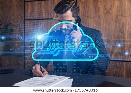 A man in office signing papers while talking phone and cloud concept hologram. Double exposure. Formal wear.