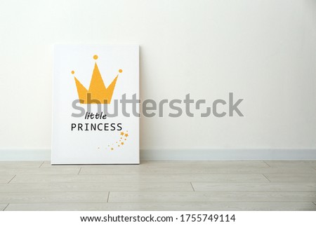 Adorable picture of crown with words LITTLE PRINCESS on floor near white wall, space for text. Children's room interior element