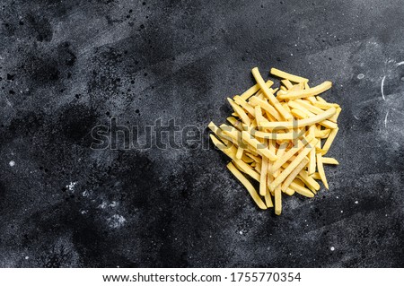 Frozen French fries, organic vegetables. Black background. Top view. Copy space