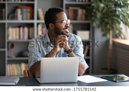 African guy freelancer or office worker take break from work seated at desk in front of laptop looking at window feels satisfied by accomplished work, visualizing relieving fatigue daydreaming concept Royalty-Free Stock Photo #1755781142