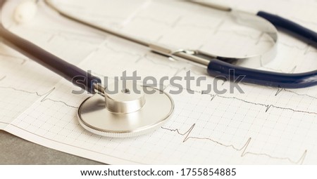 Medical stethoscope lying on cardiogram chart closeup. Medical help, prophylaxis, disease prevention or insurance concept. Cardiology care.