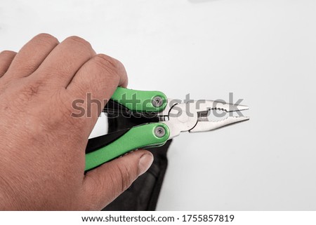 knife multitool turned into pliers in the hands of a man