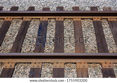 Close-up view of a section of railroad tracks with clamps, nails and ties