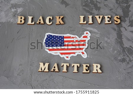 Black Lives Matter flat lay on a gray background with american flag. Fight against racism concept.