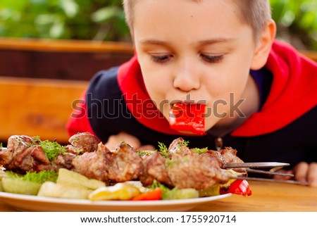 boy eat vegetables cooked on the grill. chargrill. meat.