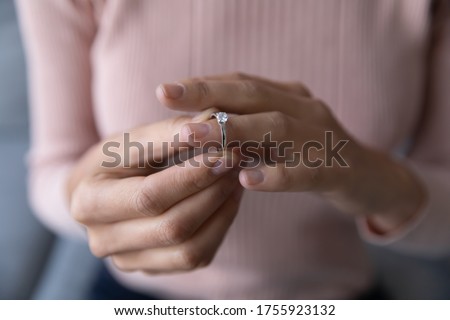 Close up young woman taking off wedding ring, divorce concept, female hands holding engagement ring, cheated girl break up with boyfriend or husband, family split, bad relationship Royalty-Free Stock Photo #1755923132