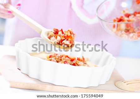 A picture of a woman preparing quiche in the kitchen