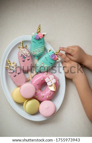 sweets in the form of unicorns. Gingerbread cookies and macaroons on a plate. Image with selective focus.