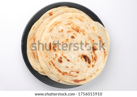 Popular breakfast dish Kerala Parotta or Paratha is a layered flatbread made from maida flour, served in ceramic plate or platter in South India.  Royalty-Free Stock Photo #1756015910