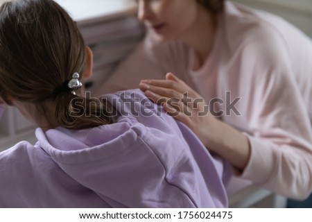 Close up back view of caring mom touch comfort upset teenage daughter having difficulties with studying at home, supportive loving mother caress console sad teen child suffering from school problems Royalty-Free Stock Photo #1756024475