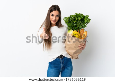 Young caucasian woman buying some food isolated on white background shaking hands for closing a good deal