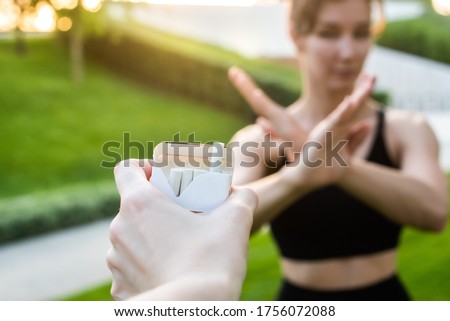 young woman refuses cigarettes. shows with hands a stop symbol. hand holds out her cigarettes. smoking cessation concept. healthy lifestyle