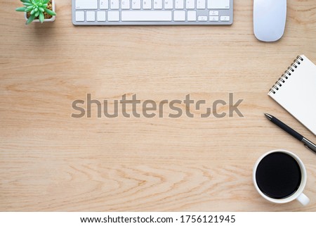 Wood office desk table with keyboard, notebook and coffee cup with equipment other office supplies. Business and finance concept. Flat lay with blank copy space.