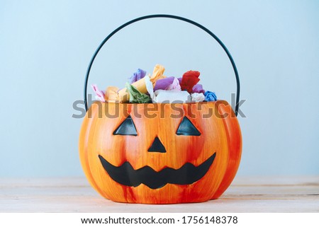 The candy put in a pumpkin-shaped basket which had a cool face, halloween party concept