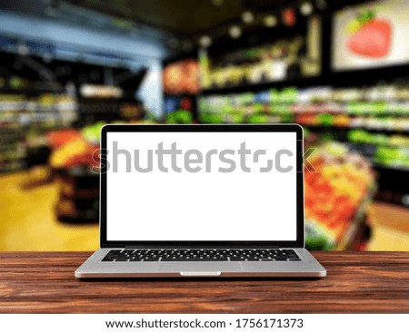 Modern computer,laptop with blank screen on table with blur supermarket