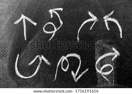 White color chalk hand drawing in set of arrow shape on black board background