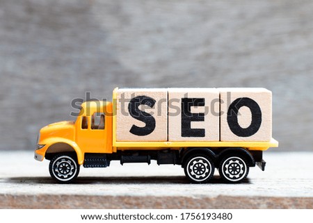 Truck hold letter block in word SEO (Abbreviation of search engine optimization) on wood background