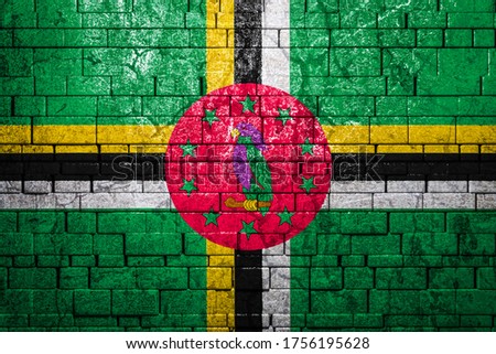 National flag of Dominica on brick  wall background.The concept of national pride and symbol of the country. Flag  banner on  stone texture background.