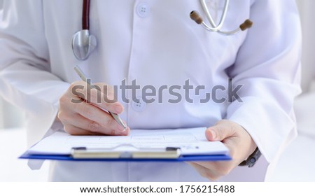 Female doctor writing medical prescription or certificate
