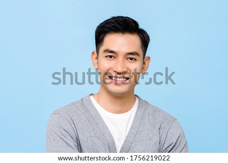 Handsome portrait of young Asian man smiling isolated on light blue background Royalty-Free Stock Photo #1756219022