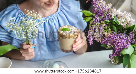 A cute young woman is enjoying an aromatic coffee on a sunny summer morning. Concept of a dreamy mood, a cozy atmosphere and a pleasant start to the day.