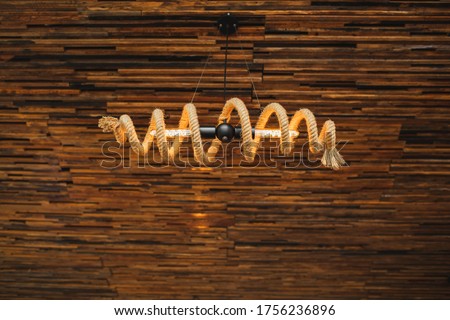 Creativity designed electric bulb lamp wrapped with rope. Eco-friendly style without plastic. Empty wooden background.