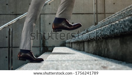 Motivation and challenging Concept. Steps Forward into a Success. Low Section of Businessman Walking Up on Staircase Royalty-Free Stock Photo #1756241789