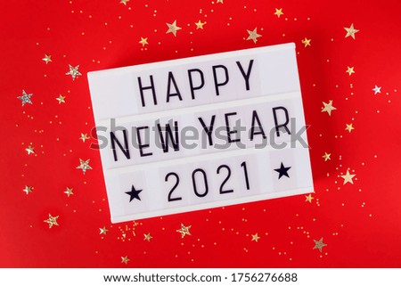 New Year or Christmas 2021 composition flat lay top view. Xmas holiday celebration  lightbox with text red background. Template for greeting card text design