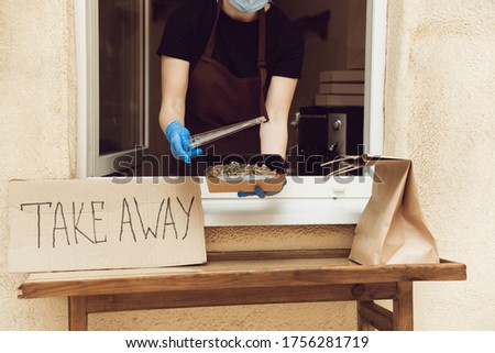 Lunch. Woman preparing drinks and meals, wearing protective face mask and gloves. Contactless delivery service during quarantine coronavirus pandemic. Take away concept. Recycable mugs, packages.