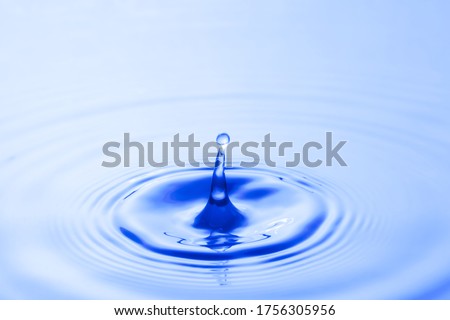 Water droplet falling impact with water surface. causing rings on water surface.