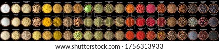 collection of condiments and herbs isolated on black background. Various spices, top view Royalty-Free Stock Photo #1756313933