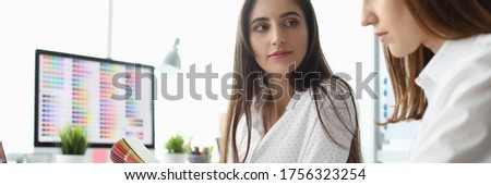 Portrait of smart businesswoman sitting at modern workplace with joyful manager discussing important charts and graphs with serious concentration. Creative office concept