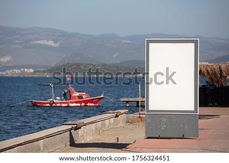 A landscape shot of advertisement stand in front of a lake