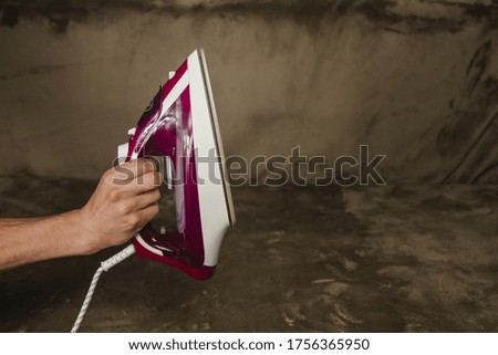 A man holds an iron in his hands