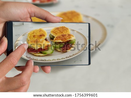 Woman photographing on cell phone homemade healthy food.