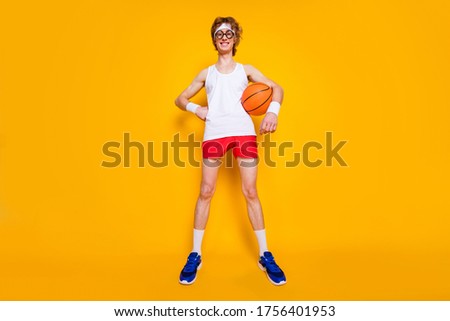 Full length body size view of nice funky successful cheerful cheery guy holding in hand orange ball amateur league season isolated over bright vivid shine vibrant yellow color background