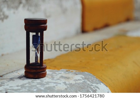 close up hourglass on old cement floor, saving and manage time to success business concept, travel and relaxation lifestyle concept