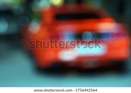 Blurred background. Red car on a city street.