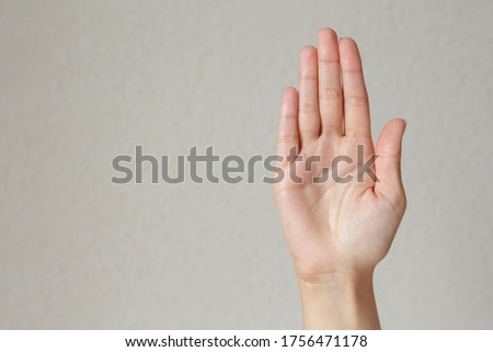 Gesture and sign, female hand showing stop on a light background